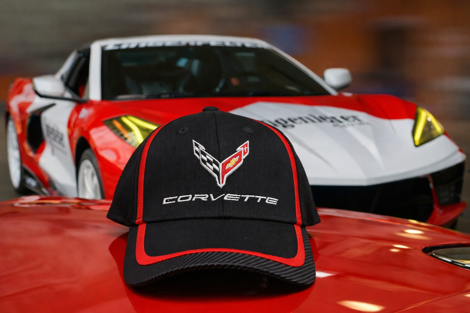 Black C8 Corvette Hat Red Trim C8 Corvette in Background Team Corvette Apparel Lingenfelter GM Licensed