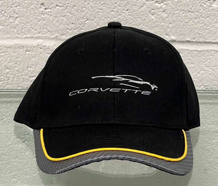 Black Corvette cap with yellow rim on a textured white background