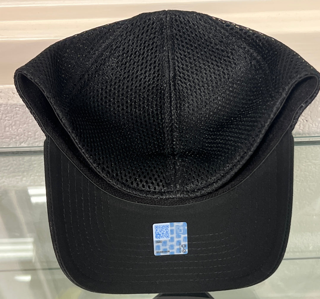 Black mesh baseball cap with a structured curved brim and a small blue-and-white sticker on the front, photographed against a light indoor background.
