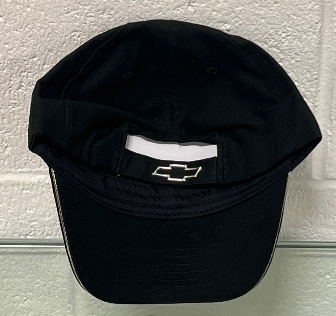Black cap with a logo on a textured white wall