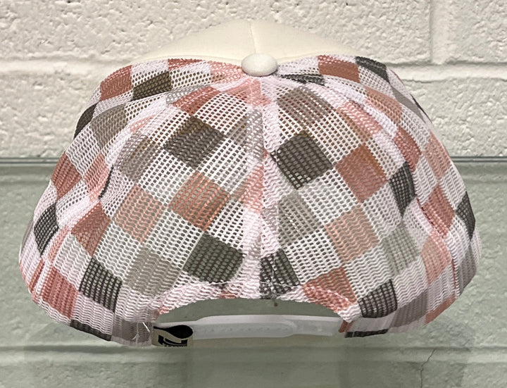 Plaid-patterned canopy over a white surface with a white brick wall background