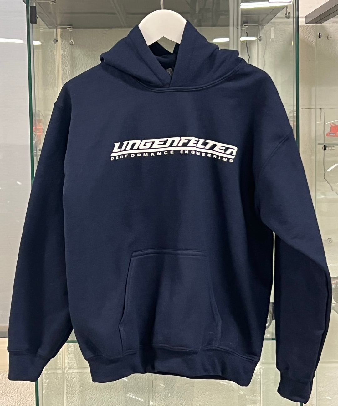 Navy hoodie with 'Ungenfelter' logo on a hanger in a store setting