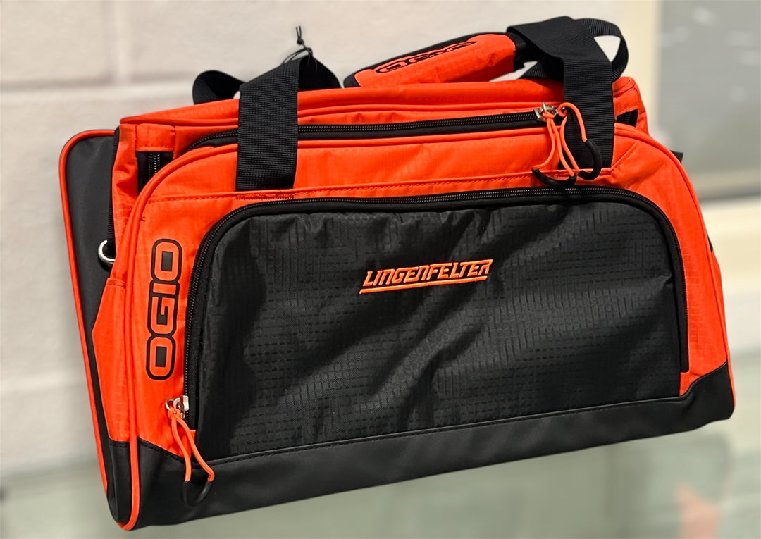 Orange and black duffel bag with visible branding on a neutral  Lingenfelter orange logo 