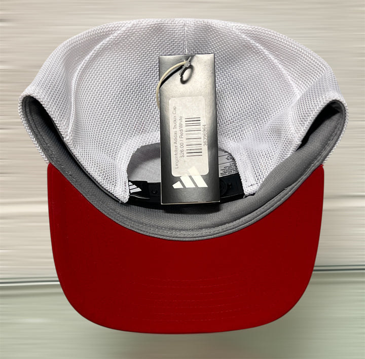 Red and gray cap with an Adidas tag on a neutral background