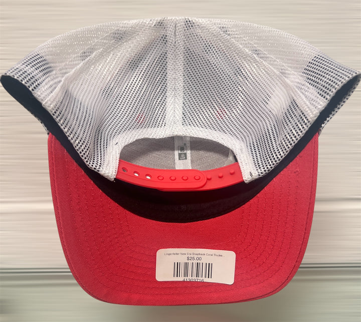 Red cap with a white mesh back and visible brand label on a neutral background