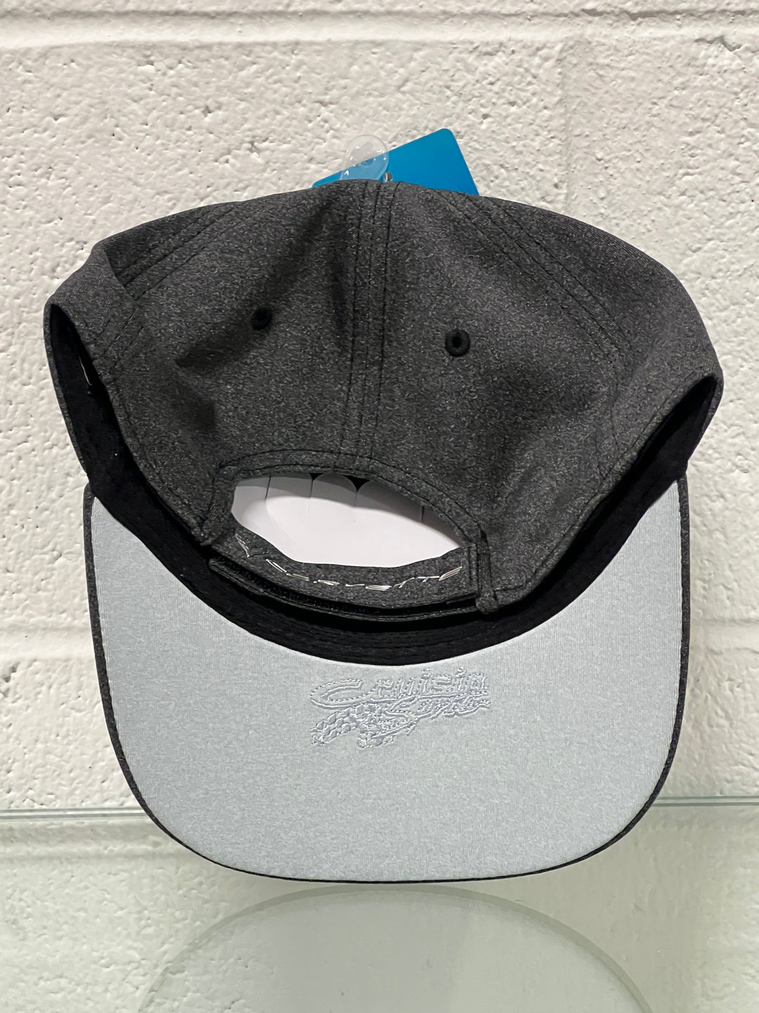 Black cap with a white patch on a textured white background