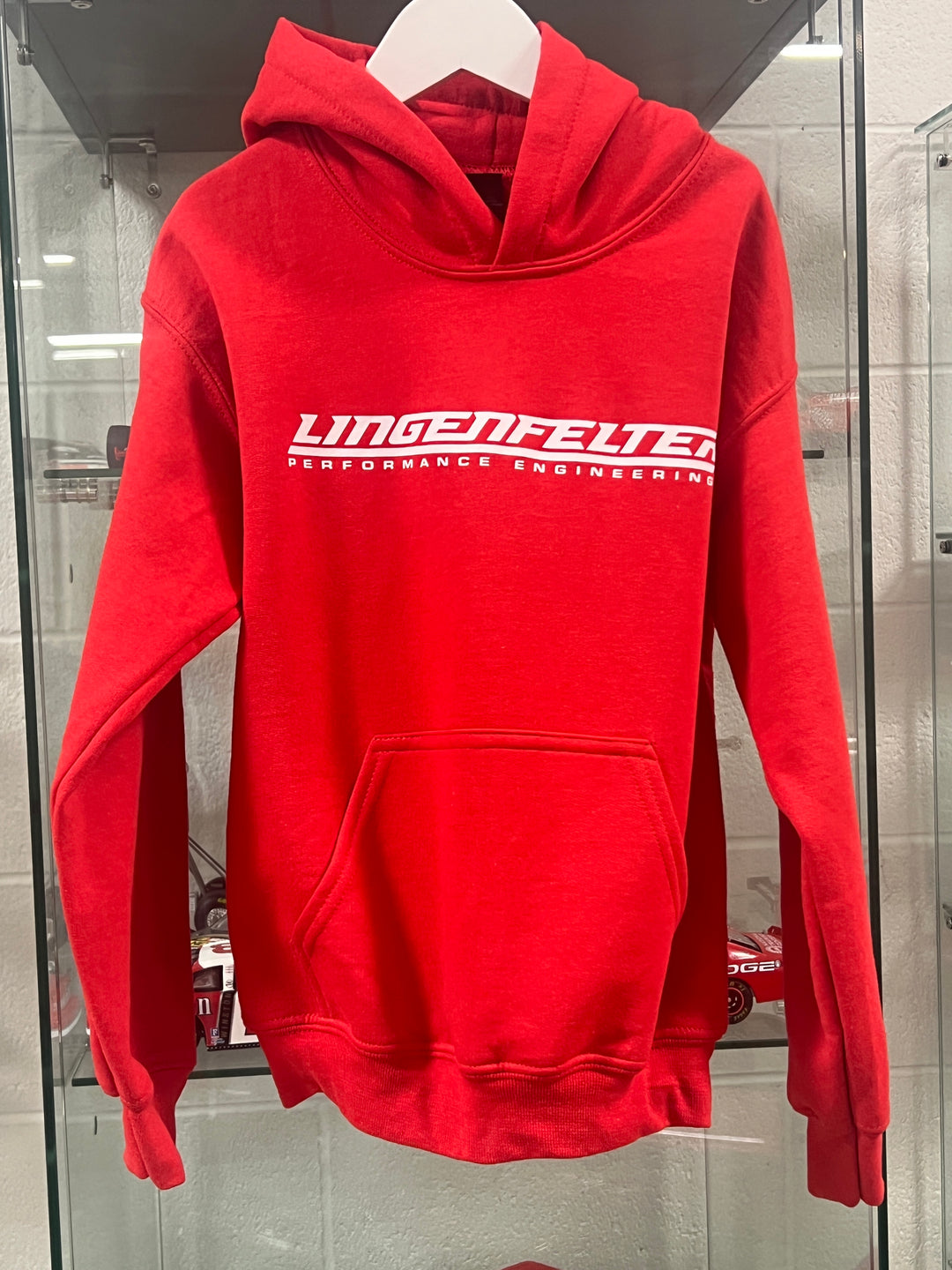 Red Lingenfelter youth hoodie featuring the Team Lingenfelter logo, made of soft fabric, perfect for comfortable youth apparel.