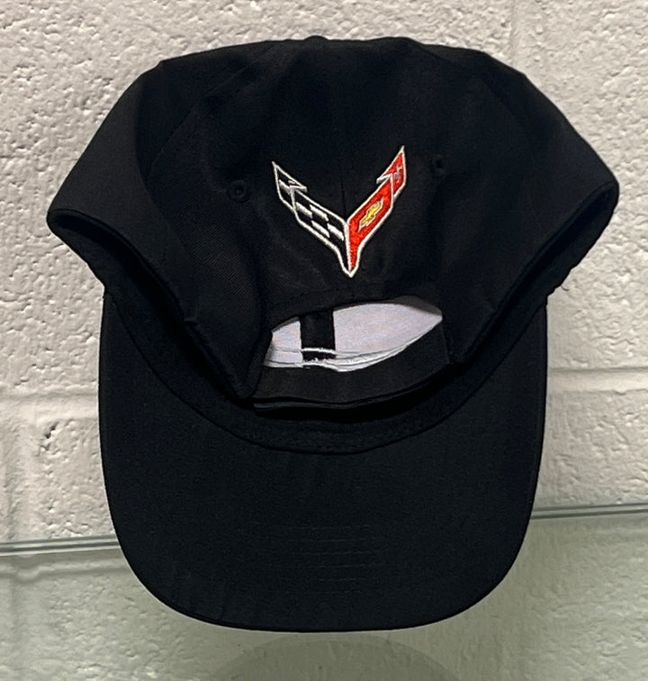 Black cap with a logo on the front against a light gray wall