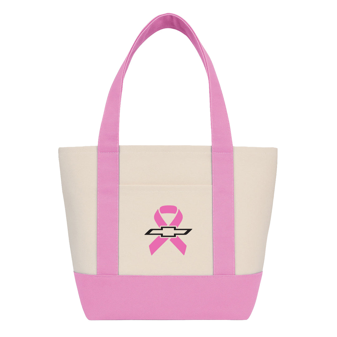 A canvas tote bag with a cream body, pink handles and bottom trim, featuring a pink ribbon and Chevrolet bowtie logo on the front pocket.